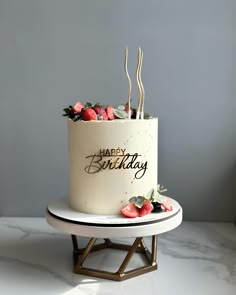 a white birthday cake with strawberries on top