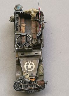 a toy army vehicle is shown on the ground with other toys in it's back