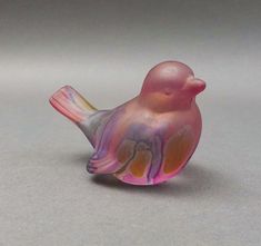 a small glass bird sitting on top of a table