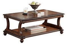 a wooden table topped with a book and a bowl of fruit on top of it