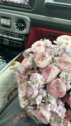 a bouquet of flowers sitting on the dashboard of a car