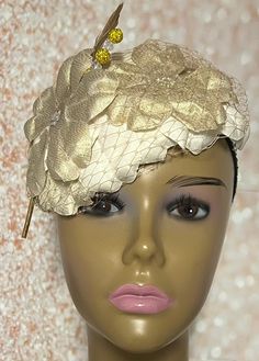 Gold and Cream Flower Fascinator Half Hat, Weddings, Church, Tea Parties, and Other Special Occasions  Accented with veil netting, feather, hat pin, and iridescent flower. The hat pin may vary and is for decorative purposes only. The hat is affixed to the head via a hatstring. Available in 2 sizes: 8 X 5.5 inches  10 X 7 inches The mannequin is wearing the 8 by 5.5 inches. Handmade Gifts for mom, sister, wife, or yourself. SHIPPING  All items for free shipping will be shipped via USPS FIRST CLAS Luxury Cream Hat Headpiece, Elegant Wedding Hats And Headpieces With Handmade Flowers, Gold Costume Hats For Spring Wedding, Wedding Costume Hats And Headpieces With Handmade Flowers, Gold Costume Hats And Headpieces For Spring Wedding, Elegant Adjustable Fascinator With Flower Decoration, Elegant Adjustable Flower Fascinator, Adjustable Wedding Headband Costume, Elegant Flower-shaped Adjustable Fascinator