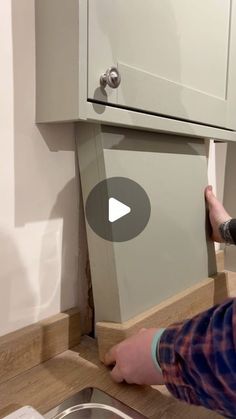 a man is opening the cabinet door with his hands