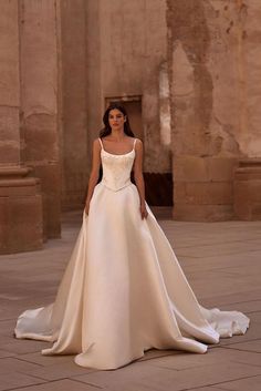 a woman in a wedding dress standing on the ground