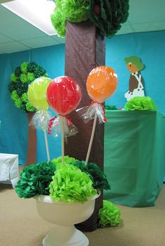 an office decorated with green and red tissue paper flowers, balloons and other decorative items