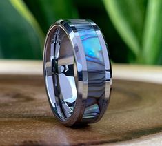 a wedding band with an abamock shell inlay and blue opal stone