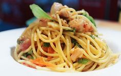 a white plate topped with pasta and vegetables