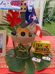 a ukulele is sitting in a basket on a table with other items around it