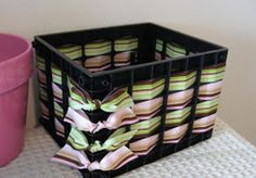 a pink flower pot sitting next to a black container filled with colorful striped napkins