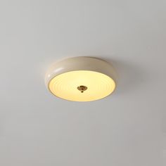 a ceiling light that is on in a room with gray walls and white flooring