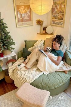 a woman is sitting on a bean bag chair in her living room reading a book