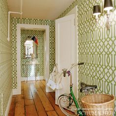 a bike is parked on the floor in front of a green wallpapered hallway