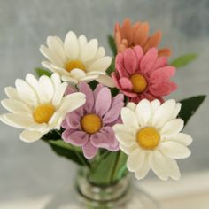 a vase filled with different colored flowers on top of a table