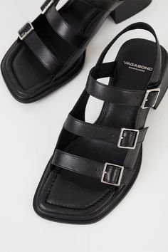 Vagabond Ines triple buckle sandal is the minimal buckle sandals for all-day wear. The style is crafted from black leather featuring adjustable straps with buckle fastening, square toes and padded insoles. The flared block heels. 53mm heels. For long-lasting care: use neutral shoe cream and protecting spray to ensure a longer lifespan for your shoes. 5711-001-20 PIPE AND ROW Clogs Heels, Neutral Shoes, Cream Shoes, Swimming Bag, Buckle Sandals, Your Shoes, Sandals For Sale, Womens Purses, Wearing Black