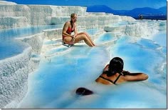 Pamukkale Turkey by the Aegean Sea. The name Pamukkale literally means “cotton castle”. At the top of the hill, you can see the Turkish country side for miles and there is a bathing pool (it cost about $10 and is worth every penny!), the water is hot and fizzy like soda. But the best part is that the pool is located over the ruined temple of Apollo and you swim over tumbled-down marble pillars. Day Trips From Istanbul, Ruined Temple, Cotton Castle, Temple Of Apollo, Voyage Europe, Aegean Sea, Country Side, Hot Spring