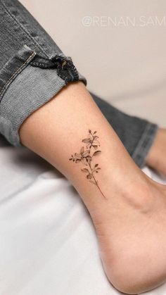 a woman's foot with a small flower tattoo on her left side calfocks