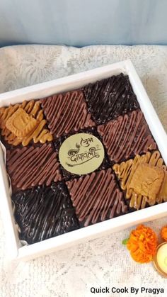 a box filled with assorted chocolates on top of a white cloth covered table