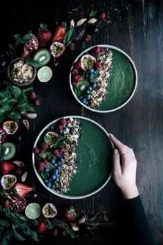 two bowls filled with food on top of a wooden table