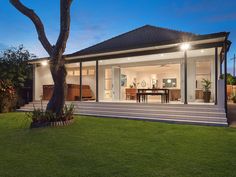 a house that is in the grass with lights on and steps leading up to it