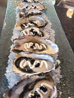 a row of oysters sitting on top of an ice covered table with toppings