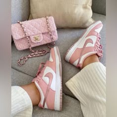 a woman's feet wearing pink sneakers and holding a pink handbag next to her purse