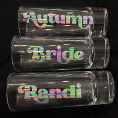 three clear glasses with the words autumn bride and rainbow lettering on them are stacked in front of each other