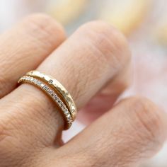 a woman's hand wearing a gold ring with diamonds on the inside of it