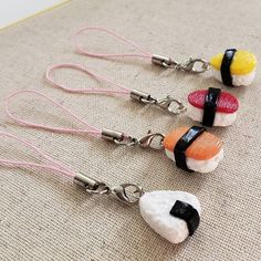 three different types of sushi earrings on a table