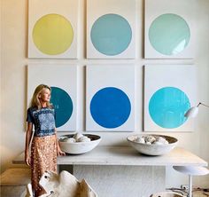 a woman is standing in front of some bowls and plates on a table with blue circles