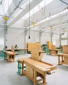 a large room filled with lots of wooden tables and workbench set up in it