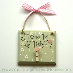 a sign hanging from the side of a wall with a pink bow on it that says mums to do list