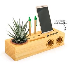 a cell phone is sitting on top of a wooden device holder with two holes in it