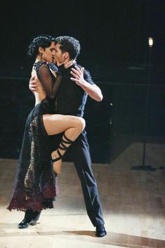 a man and woman are dancing on stage