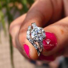 a woman's hand holding a diamond ring