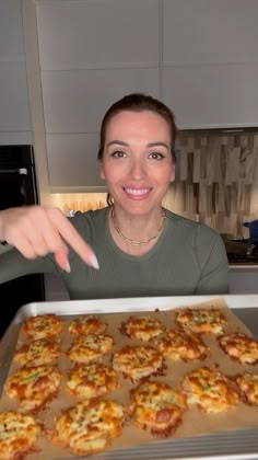 a woman pointing at some food in a pan