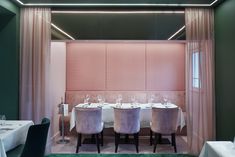 the dining room is set for four with white tablecloths and purple velvet chairs