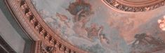 an ornate ceiling with paintings and chandeliers