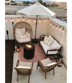 an outdoor patio with wicker furniture and string lights on the ceiling, along with a fire pit