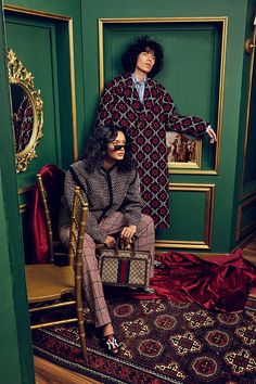 an image of two people that are sitting on the floor in front of a green wall