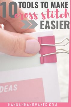 a hand holding some pink clothes pins with the words 10 tools to make cross stitch easier