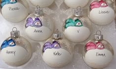 twelve personalized glass christmas ornaments with snowflakes and name written on one ornament