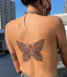 a woman with a butterfly tattoo on her back