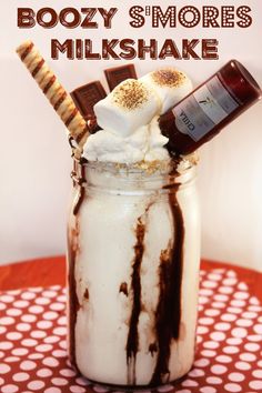 there is a milkshake with marshmallows and chocolate in it on the table