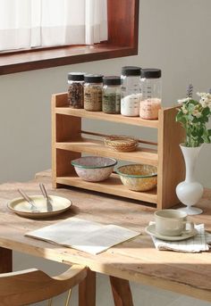 a wooden table topped with bowls and plates