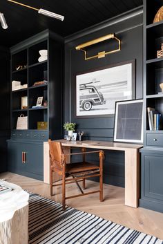 a home office with black walls and wooden furniture