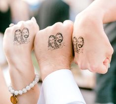 two people holding hands with tattoos on their arms and wrist, one has a couple's faces drawn on it