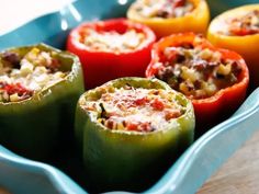 several stuffed peppers in a blue dish on a wooden table