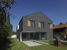 the house is made out of concrete and has large windows