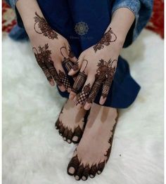 a woman's hands with henna tattoos on them