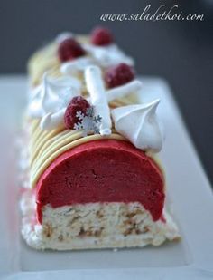 a piece of cake with raspberries and cream on it sitting on a white plate